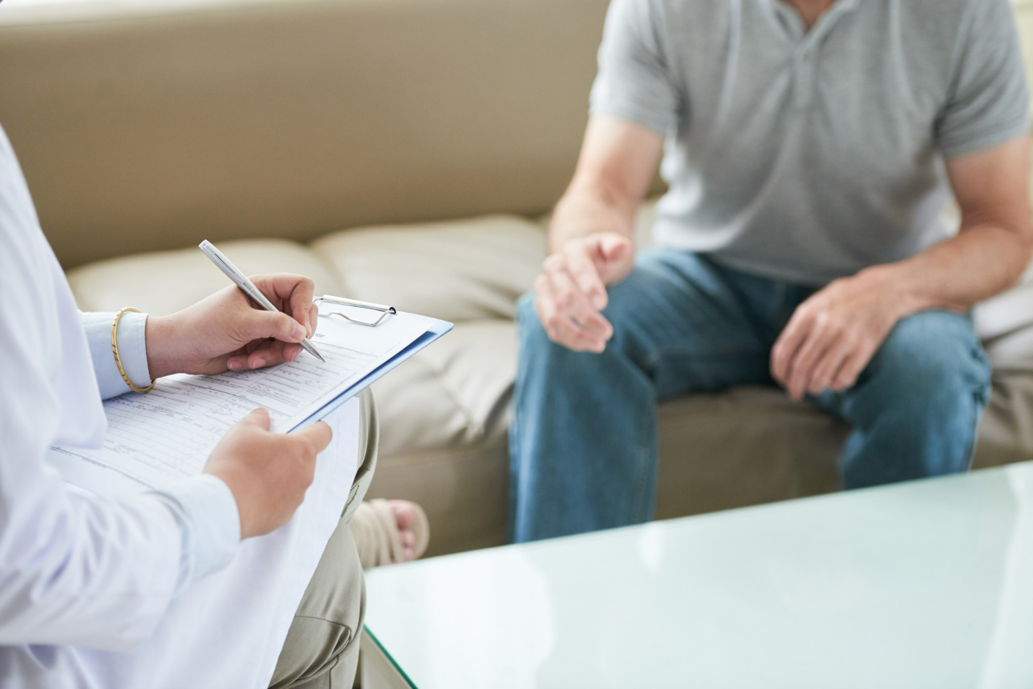 A psychiatrist meets with a patient in a calm office, taking notes during a focused mental health evaluation